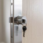 Comment un locataire peut-il changer la serrure sans prévenir son propriétaire ? Gros plan réaliste sur le cylindre de serrure et le trousseau de clés d’une porte d’entrée d’appartement vue de l’intérieur, dans une ambiance claire et sobre.